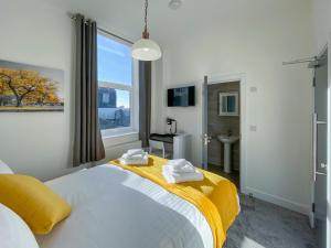 a bedroom with a large bed with towels on it at Piccadilly by Pureserviced in Plymouth