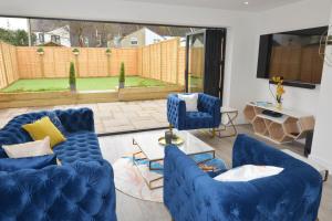 a living room with blue furniture and a large window at Outstanding modernised 3/4 double bedroomed house in Littlehampton