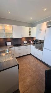 uma cozinha com armários brancos e uma bancada em Kirkjufell central apartment em Grundarfjordur