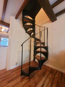 a spiral staircase in a room with wooden floors at Heptonstall Cottage, Heptonstall, Hebden Bridge in Heptonstall