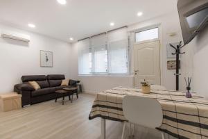 sala de estar con mesa y sofá en 4Torres Homes - Carmen, en Madrid