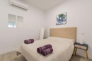 um quarto com uma cama com duas almofadas em 4Torres Homes - Carmen em Madri