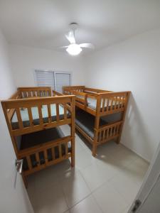 two chairs and a table in a room at APTO FAMILIAR EM BERTIOGA JARDINS DO INDAIÁ A 500 M Praia in Bertioga