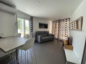 ein Wohnzimmer mit einem Tisch, Stühlen und einem Sofa in der Unterkunft Apartamentos Apolo VII 7-1º-11 in Calpe