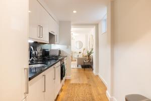 The Paddington Escape - Modern & Bright 2BDR Flat with Patio في لندن: مطبخ مع دواليب بيضاء ومغسلة