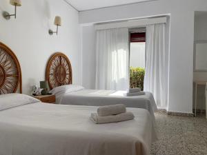a hotel room with two beds with towels on them at Hostal Paco Marbella in Marbella