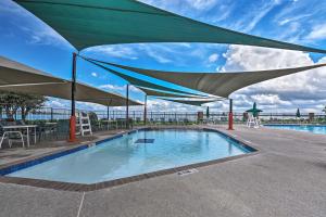 a swimming pool with a large umbrella over it at Idyllic Montgomery Condo with Pool and Lake View! in Montgomery