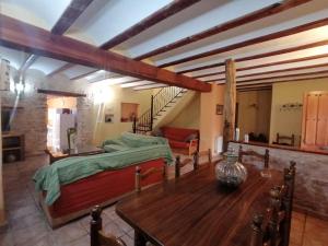 ein Schlafzimmer mit einem Bett, einem Tisch und einer Treppe in der Unterkunft Casas Rurales Tío Segundo in Carcelén