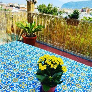 un tavolo blu e bianco con fiori gialli sul balcone di Casa la Roccia a Sant'Agnello