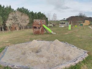 a pile of sand in a field with a playground at tiny house in Saint-Vallier