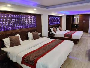 duas camas num quarto de hotel com luzes roxas em Hotel Hamers International em Mussoorie