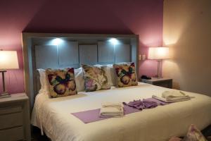a bedroom with a large bed with purple walls at Hotel Casa Don Quijote in San Miguel de Allende