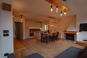 a kitchen and living room with a table and chairs at Alpenrooms in Transacqua