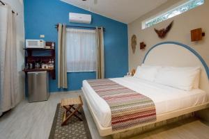 a bedroom with a bed with a blue wall at ALDEA JO-YAH in Tulum