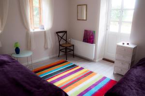 a living room with a bed and a colorful rug at Skelstrupgaard Apartments in Maribo