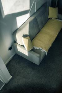 - un canapé avec deux oreillers dans l'établissement Apartments Dealhouse 4, à Huddersfield