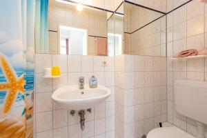 a bathroom with a sink and a toilet at Pension Zum Lindeneck in Lübz +38 photos