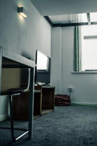 a room with a tv and a table and a chair at Apartments Dealhouse 4 in Huddersfield