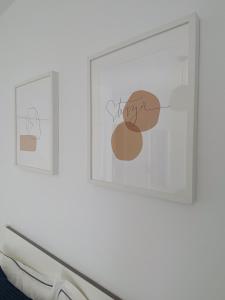 two framed pictures on a white wall in a room at Apartamentos Cataira in Costa Teguise