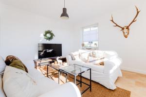 a living room with two white couches and a table at Zuhause auf Zeit in Osterode