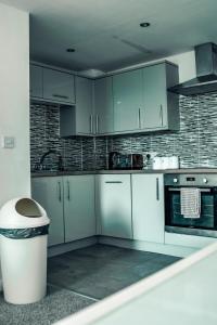 una cucina con armadi blu e un cestino della spazzatura di Apartments Dealhouse 4 a Huddersfield