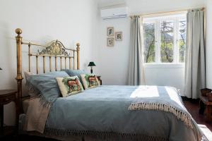1 dormitorio con cama con sábanas azules y ventana en Casona El Resguardo - Solo Adultos, en Río Blanco