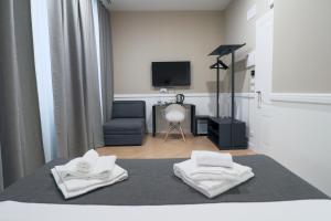 sypialnia z łóżkiem i dwoma ręcznikami na nim w obiekcie Elisabeth Boutique Rooms w Trieście
