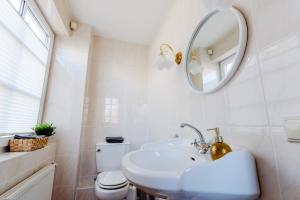 a white bathroom with a sink and a mirror at Zuhause auf Zeit in Osterode +6 photos