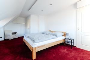 a bedroom with a wooden bed on a red carpet at Zuhause auf Zeit in Osterode