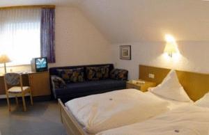 ein Hotelzimmer mit einem Bett und einem Sofa in der Unterkunft Zum Ochsen in Hauenstein
