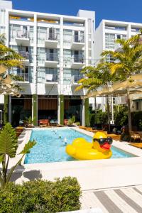 un canard en caoutchouc jaune dans une piscine en face d'un bâtiment dans l'établissement The Fairwind Hotel, à Miami Beach