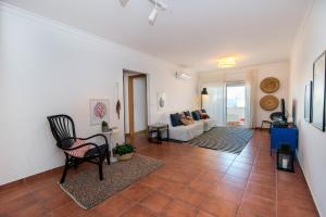 - un salon avec un canapé et une chaise dans l'établissement Apartamento Santa Luzia, à Santa Luzia