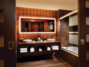 ein Badezimmer mit zwei Waschbecken, einem Spiegel und einer Badewanne in der Unterkunft Golden Nugget Hotel & Casino Las Vegas in Las Vegas