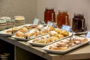 a buffet filled with different types of pastries and jams at InStyle Aparthotel in St. Julianʼs +9 photos