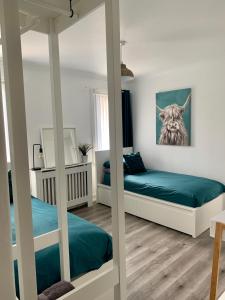 Nevis Rooms - Self check in with free onsite Parking في Inverlochy: غرفة نوم بسريرين بطابقين ولوحة الياك