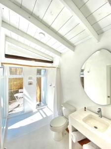 a bathroom with a toilet and a sink and a mirror at Hotel Cala Blanca Cuernavaca in Cuernavaca