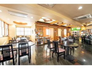 Green Hotel Omagari - Vacation STAY 19287v في Daisen: غرفة طعام مع طاولات وكراسي في مطعم