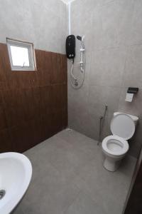 a bathroom with a toilet and a shower and a sink at 8 Wooden Inn LOT 1806 in Kampong Alor Gajah