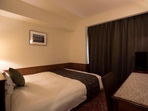 帯広市にあるプレミアホテル-CABIN-帯広のベッドと窓が備わるホテルルーム
