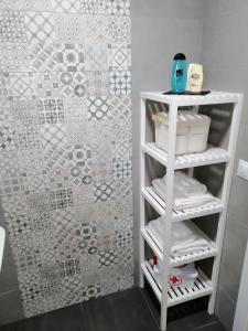 a bathroom with a white shelf with towels at Apartamento MyR in Benajarafe