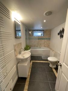 uma casa de banho com uma banheira, um lavatório e um WC. em Gorgeous 1 bed apartment with breathtaking views em Lydden