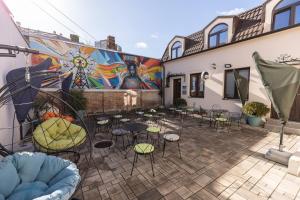 a patio with chairs and tables in front of a mural at City SMART in Niš