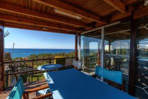 dom z niebieskim stołem i krzesłami na balkonie w obiekcie KariBa House - Sunset view w mieście Nea Potidaea