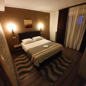 una camera d'albergo con letto e finestra di Guest House Babilon a Prijedor