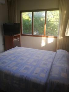 1 dormitorio con 1 cama, TV y ventana en Grand Hotel Mercedes, en Pucallpa