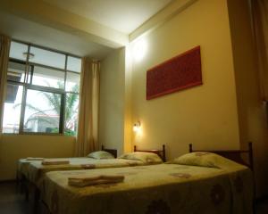 two beds in a room with a window at Grand Hotel Mercedes in Pucallpa