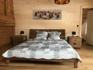 a bedroom with a bed and a painting on the wall at Au Pré des Chevaux in Chateau-d'Oex