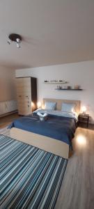 a bedroom with a large bed with a blue blanket at Marge’s cosy Old Town Nest in Braşov