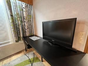 uma televisão de ecrã plano sentada numa mesa ao lado de uma janela em Huoneisto Tikkakoski - Apartment in Tikkakoski em Tikkakoski