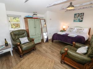 a bedroom with a bed and two chairs at Five Elements Studio in St. Agnes